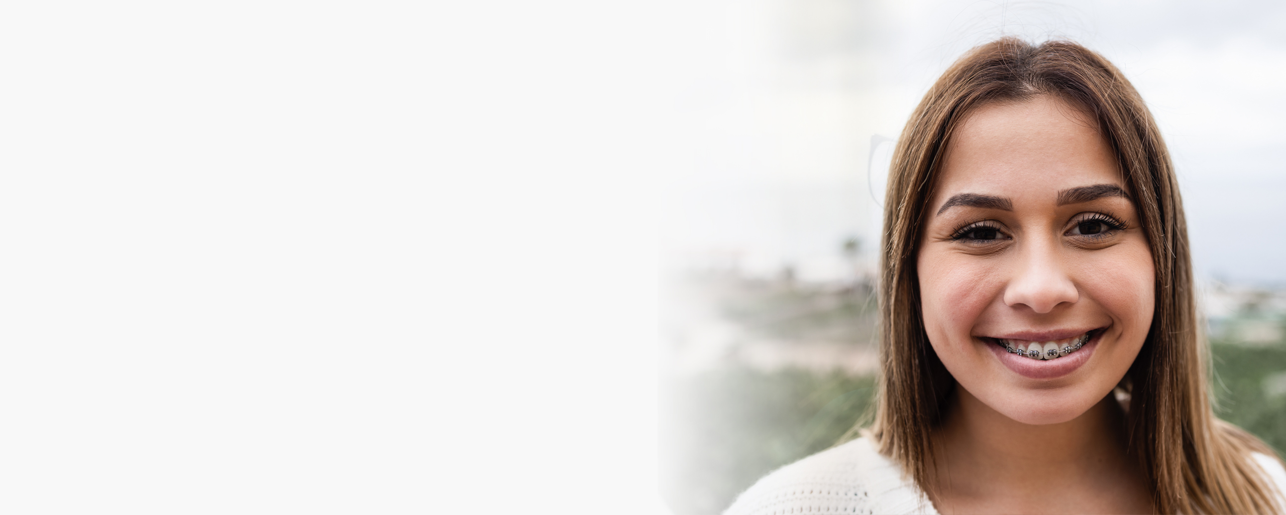 Young woman smiling at camera, professional headshot for dental practice website